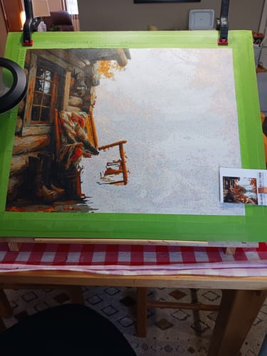 Reviewer's 'The Loyal Rest' paint-by-numbers canvas, partially completed on a work stand.