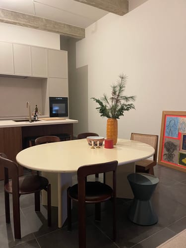 Klantfoto van meerdere bruine HAY Rey Stoelen opgesteld rond een ovale eettafel.