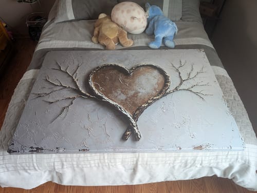 Customer showing the Golden Heart Branch Wall Art on a bed. The large canvas has a textured, 3D-like appearance.