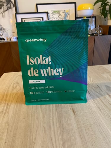 Sachet d'Isolat de Whey Native vanille d'un client, posé sur une table en bois.
