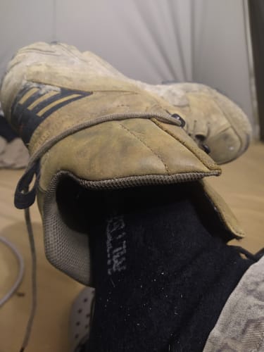 Close-up of a customer wearing the black Men's Alpaca Socks inside a worn hiking boot.