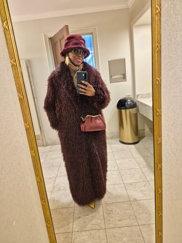 Reviewer taking a mirror selfie while wearing the long, plush Faux Fur Plush Long Coat.
