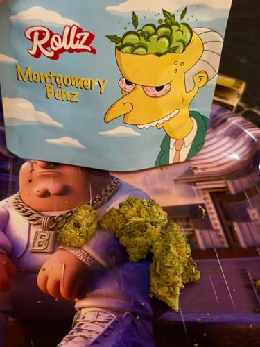 Customer's green Montgomery Benz THCA Flower buds sitting on a tray in front of the product's illustrative packaging.