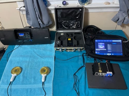 Customer's full Qi Coil 3S System laid out, showing coils on a towel, the console, open case, and connected tablet.