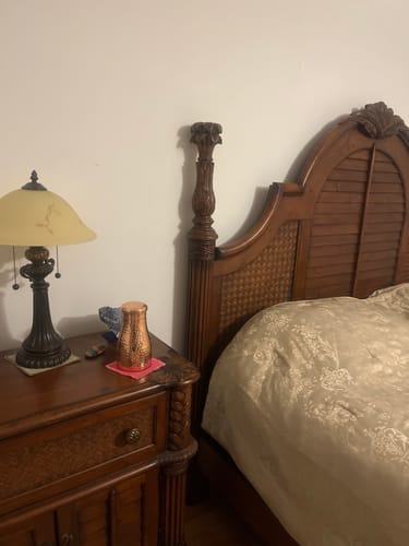 Reviewer's copper Himalayan Ayurvedic Bedside Carafe on a wooden nightstand.
