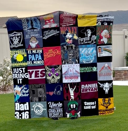Customer's large Premium T-Shirt Quilt made from various t-shirts, displayed upright on a green lawn.