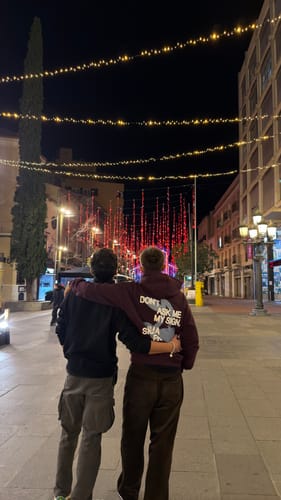 Reviewer seen from behind wearing the dark, wide-leg Los Pantalones — Pana on a city street at night.