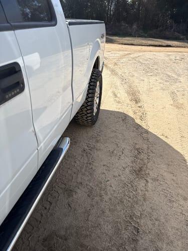 Customer's white truck viewed from the side, showing the wider wheel stance from the installed 2-inch hubcentric wheel spacers.