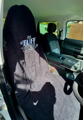 Customer's black Waterproof Car Towel Seat Cover draped over the driver's seat in their car.