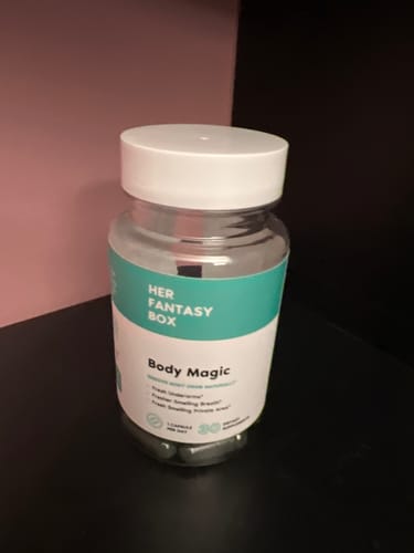 Customer's clear bottle of Body Magic chlorophyll pills with a white lid, resting on a dark shelf.