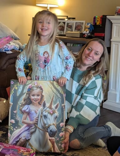 A reviewer and a smiling child hold up their new Lavender Unicorn Princess portrait in a living room.
