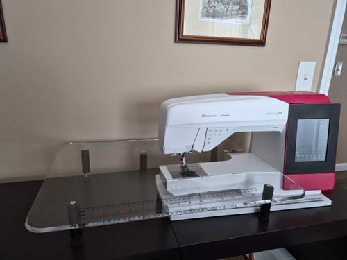Customer's Sew Steady Extension Table fitted to their white and red sewing machine, creating a large, flat work surface.