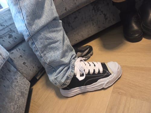 Reviewer draagt de Maison Mihara Yasuhiro sneaker aan de voet, gecombineerd met een lichte spijkerbroek.