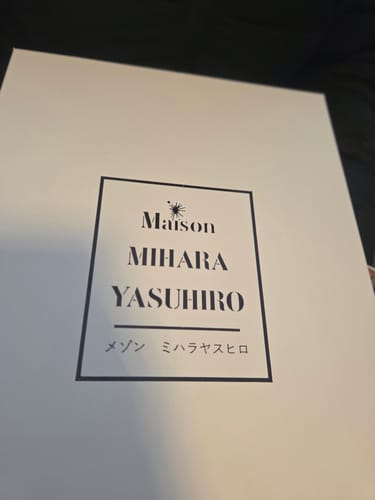Verpakking voor de Maison Mihara Yasuhiro sneakers, met het merklogo op de witte doos.