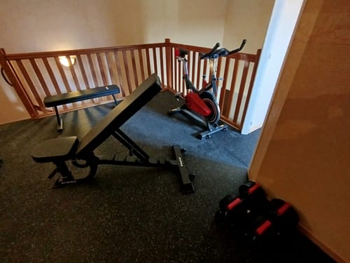 Kundenfoto der schwarzen B2 Hantelbank, die in einem Heim-Fitnessstudio in Schrägstellung aufgebaut ist.