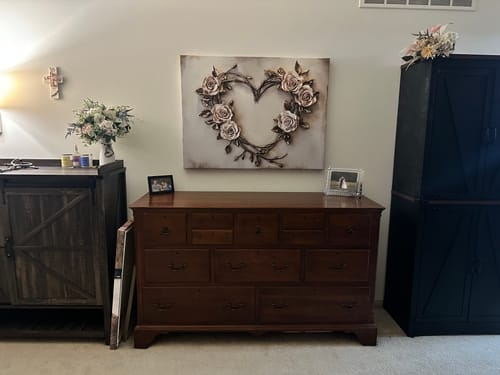 Customer's beautiful rose heart wall art hanging above a wooden dresser in their bedroom.