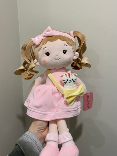 Customer holding the soft Personalized Milly Girl doll, which wears a pink dress and has a small cat in a yellow purse.