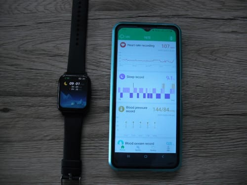 Reviewer's GARD PRO Health Smartwatch 2 shown next to a smartphone with the companion health app.