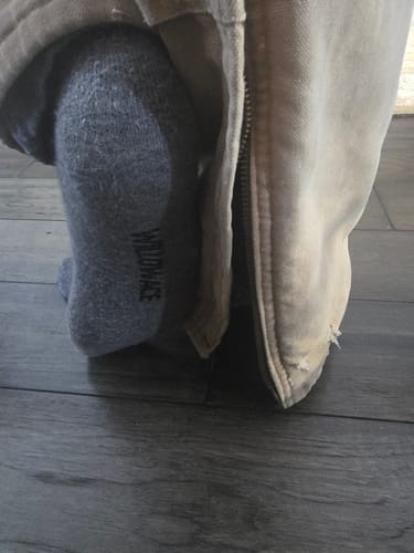 Close-up of a reviewer wearing a thick gray Men's Alpaca Sock with a pant leg pulled up.