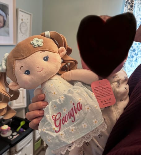 Reviewer's granddaughter holding a blue Melia Girl doll personalized with the name 'Georgia' on its dress.