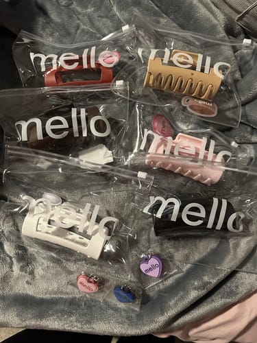 Reviewer displays a collection of colorful cloud clips in their original packaging on a soft gray blanket.