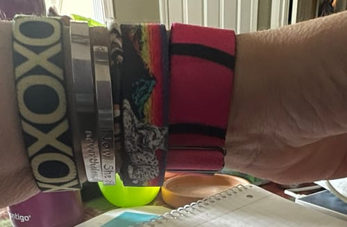 Customer's wrist stacked with several different colorful bracelets, showcasing their collection.