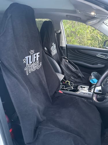 A customer's two black Tuff Towel seat covers fitting well on the sporty front seats inside their car.