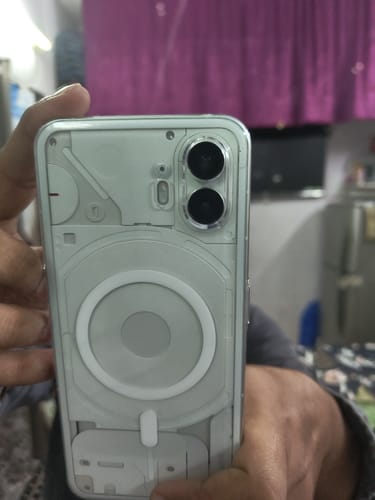 A customer's hand holds a Nothing (PH 2) phone inside the clear Anti Yellow Magsafe case.