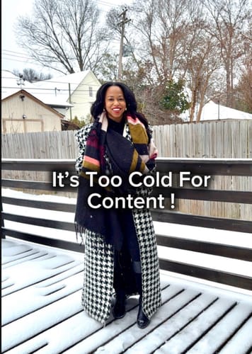 Reviewer wearing the Jacquard Houndstooth Long Coat with a large scarf while standing on a snowy deck, illustrating its use in cold weather.