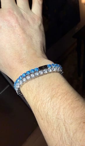 Customer's wrist showing two stacked TENNISBOY BRACELETS, one with light blue stones and one with white stones.