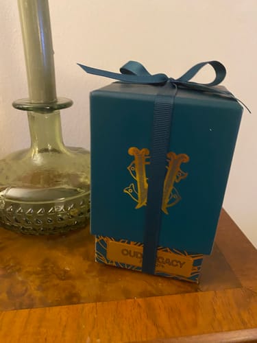Customer's Oud Legacy perfume, shown in its beautiful teal gift box with a ribbon.