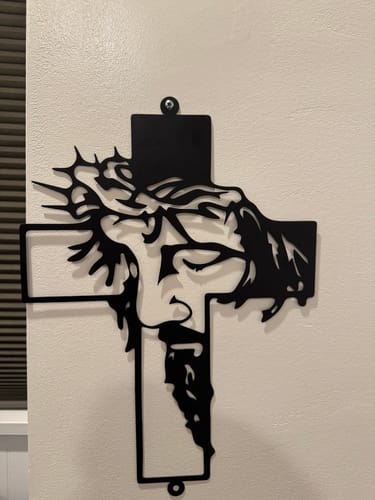 Customer's black metal Jesus with Crown of Thorns cross decor mounted on a white wall.