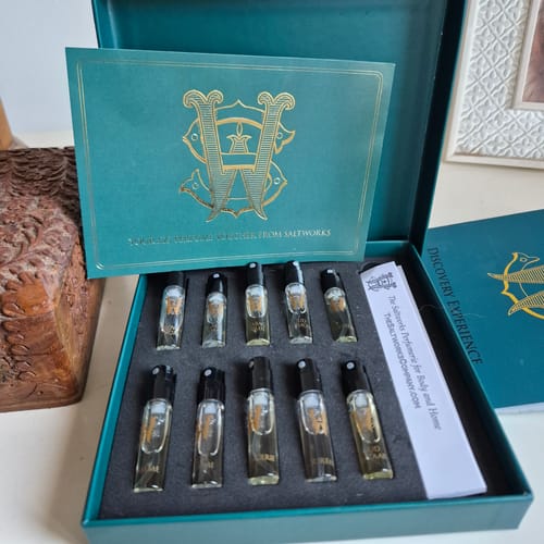 Customer's Discovery Set in an open teal box, showing ten perfume sample vials arranged inside.