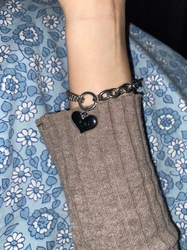 Ein Kunde trägt das Chunky Heart Armband in Silber mit graviertem Herzanhänger am Handgelenk.