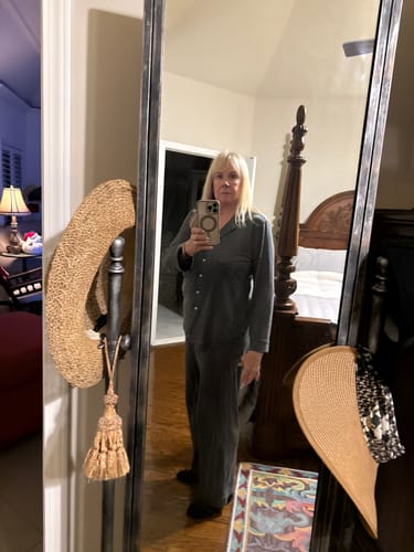 Reviewer in a bedroom wearing the dark grey, wide-leg Maya Lounge Pants as part of a pajama set.