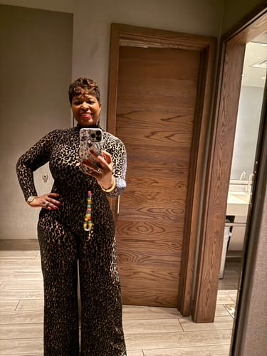 Reviewer posing in a mirror selfie, wearing the leopard print Burnout Wide-Leg Jumpsuit.
