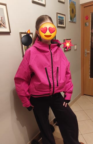 Reviewer standing indoors wearing the rose multifunctional waterproof snow jacket.