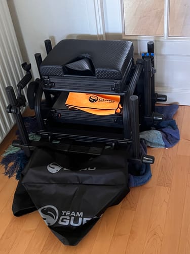 Recensent toont de STEALTH TEAM GURU SEATBOX 2.0, gemonteerd in huis met een extra lade en draagtas.
