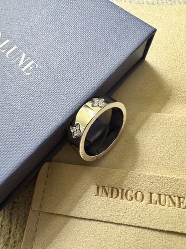 Customer's Eloise Ring, a platinum-plated band, shown with its blue box and beige pouch.