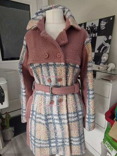 Customer's handmade coat from Heritage Check Boucle Fabric, shown belted on a dress form in a room.