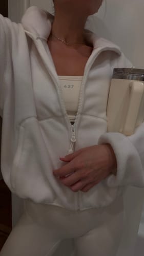 Customer wearing the cream Micro Bra under an open jacket, showing the '437' logo on the front.