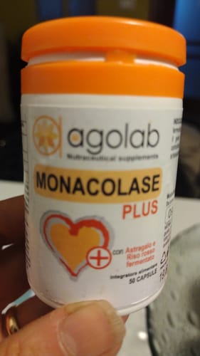 Cliente che tiene in mano il flacone bianco di Monacolase Plus con tappo arancione.