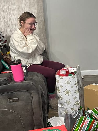 Customer with a surprised, happy expression after receiving the Premium T Shirt Quilt as a gift.