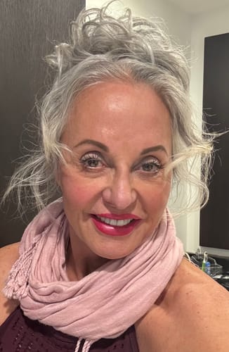 Reviewer smiling while wearing the silver Premium Messy Bun that blends naturally with her hair.