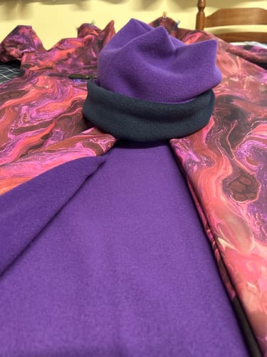 Reviewer used the purple polar fleece fabric to line a patterned coat and make a matching hat.