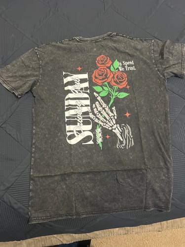 Customer's ROSES STONE WASHED TEE laid out, showing the large back graphic with a skeleton hand and roses.