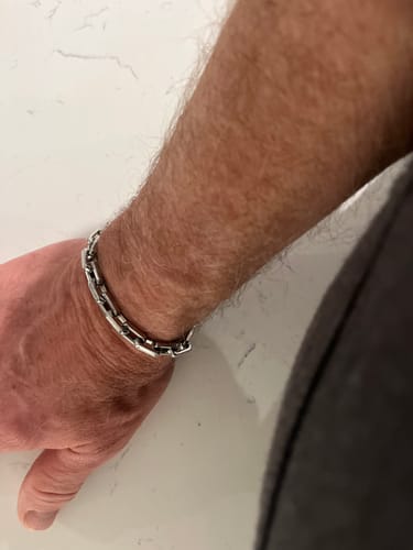 Reviewer showing the shiny Elongated Steel Link Bracelet on their wrist.