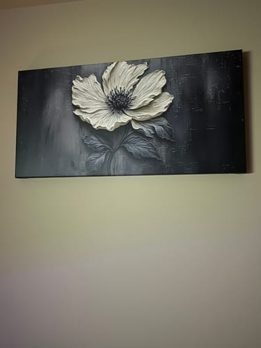 Customer's Floral Clay Relief Wall Art hanging on a light-colored wall, showing the textured white flower.