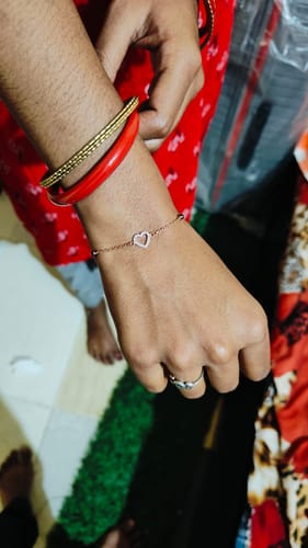 Close-up of a customer's wrist wearing the rose gold Dashing Love Mangalsutra Bracelet with its heart motif.