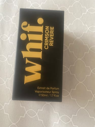 Customer holding the black and gold box for their Crimson Reverie perfume.